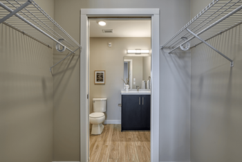 A bathroom with a toilet, sink, and a cabinet.